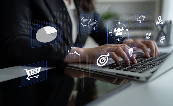 Professional businesswoman typing on laptop with digital marketing icons and graphs, showcasing data analysis and online commerce strategy concepts Haptic.