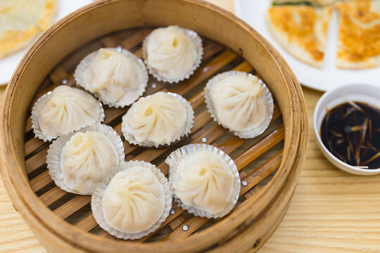 Steamed soup dumplings in bamboo steamer on table