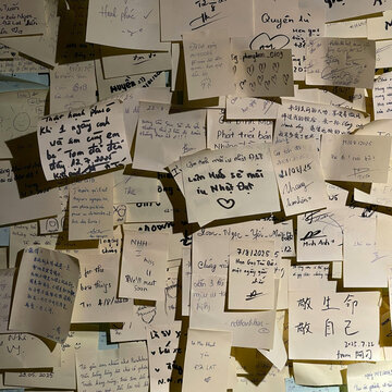 Wall of handwritten message notes and sticky memos with personal wishes and travel memories in a textured collage composition