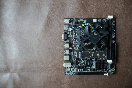 Computer motherboard with cooling fan on fabric background