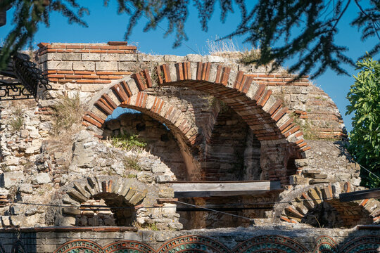 Ancient Roman or medieval brick and stone architectural ruins feature historic arched structures under a clear blue sky, Nesebar, Bulgaria