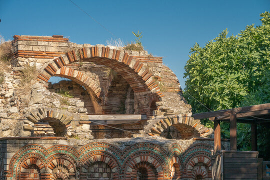Ancient Roman or medieval brick and stone architectural ruins feature historic arched structures under a clear blue sky, Nesebar, Bulgaria