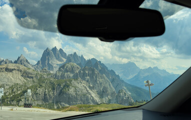 Fototapeta premium Mountains mirror on a road at sunset, concept of travel, journey, and looking back at the past. 