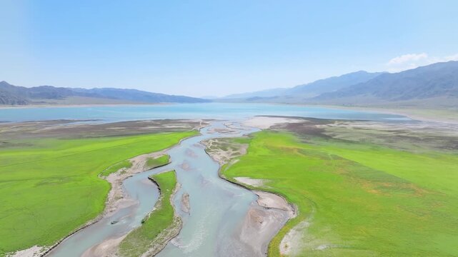 Aerial drone approaches Orto-Tokoy reservoir over Chu River in Kyrgyzstan in summer.