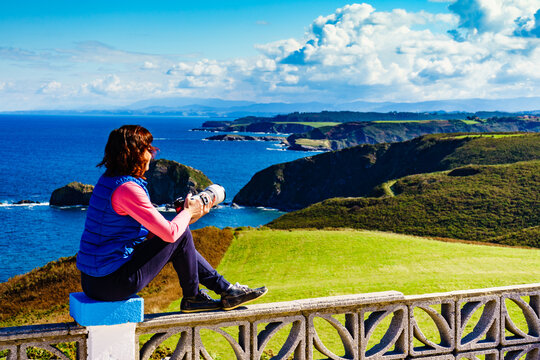 Tourist with camera on Asturias coast, Spain