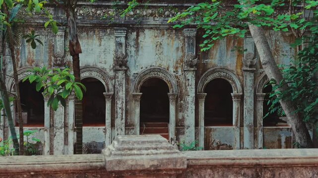 Historic Wat Phra Lat temple facade with weathered stone arches and ornate architecture, Ancient Buddhist monastery exterior by tropical trees and heritage masonry, Chiang Mai, Thailand