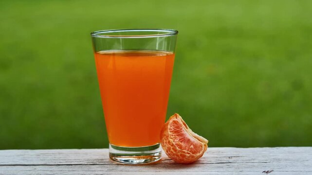 Fresh orange juice in a glass under natural sunlight