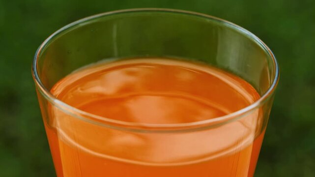 Fresh orange juice in a glass under natural sunlight