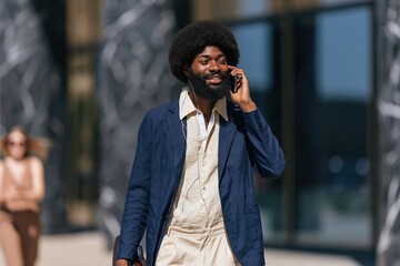 Fototapeta premium Bearded professional man walking outdoors with phone and briefcase for urban business background and banner design showing confident executive lifestyle