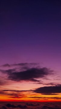 Vertical timelapse of a vibrant sunset sky with moving clouds and a smooth orange to purple gradient