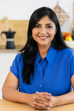 Portrait of smiling Indian businesswoman at home workspace. Mid adult female professional showing confidence and approachability. Corporate lifestyle concept