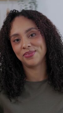 Vertical HD video portrait of young African American businesswoman smile at camera at home. Happy young professional showing confidence in a modern kitchen while working remotely