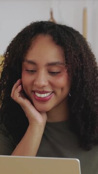 Vertical HD video of young African American woman using laptop while working from home. Female professional working remotely in a modern kitchen with a focused expression. Remote work concept