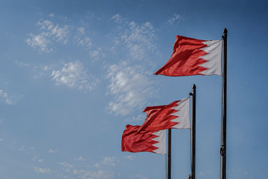 Bahrain National Flags Waving in the Wind Against a Clear Blue Sky, Symbolizing National Pride, Patriotism, Identity, Heritage, and the Spirit of the Kingdom of Bahrain
