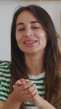 Vertical POV screen view of young Latin American woman talking with colleague on laptop video call from the kitchen at home. Headshot of confident professional female having an online conversation. 