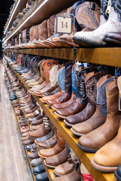 Choosing western leather shoes. Variety of fashion cowboy male boots. Fashionable footwear. Fashion footwear store. Boot male fashion shop. Shopping cowboy boots. Stylish western shoes boutique