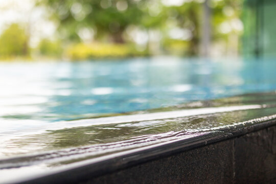 Empty stone edge of swimming pool with blurred background for product display