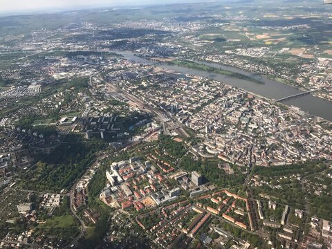 Aerial cityscape divided by a river near Frankfurt in Near Frankfurt, Frankfurt, Germany. The image presents the urban environment and city life in a clear, factual travel photograph.