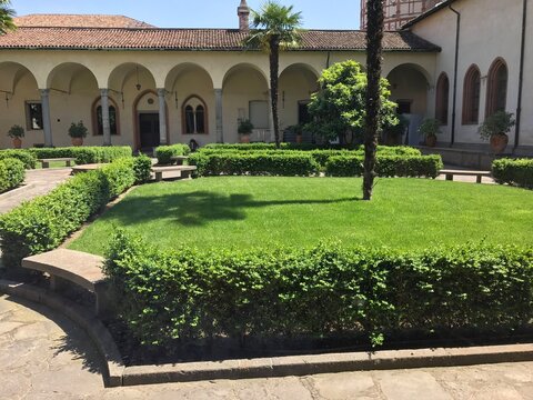 Landscaped cloister garden at Santa Maria delle Grazie in Santa Maria delle Grazie, Milan, Italy. The image presents architecture, heritage, and tourism in a clear, factual travel photograph.