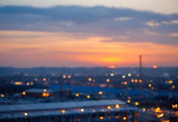 Fototapeta premium Blurred Cityscape at Sunset with Warm Sky and Bokeh Lights