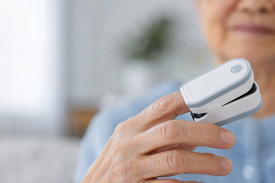 Macro Close-Up of Elderly Hand Using Fingertip Pulse Oximeter at Home