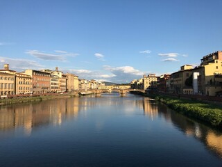 Naklejka premium Golden evening view across the Arno River in Florence in Arno River, Florence, Italy. The image presents the urban environment and city life in a clear, factual travel photograph.