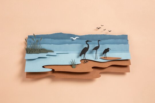 Layered Paper Craft Landscape Featuring Silhouette Herons Standing by a Peaceful Wetlands Shoreline