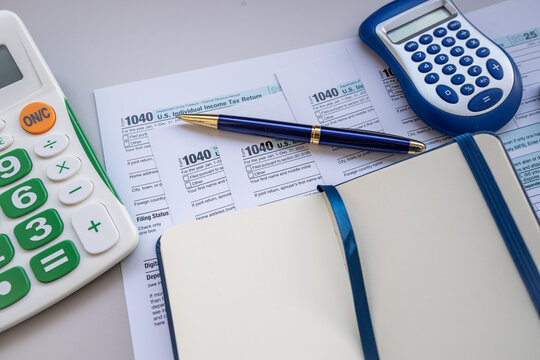 Tax Return Form 1040 Papers with Calculator Notebook and Pen for Personal Financial Planning