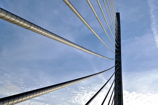heavy steel suspension bridge draw cables in diminishing perspective view looking up. abstract closeup detail. blue sky background. famous bridge in Valencia, Spain. architecture, travel and tourism