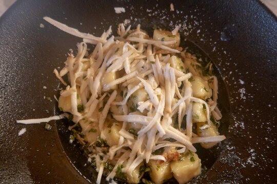 Gnocchi with celeriac and herbs served in a dark bowl