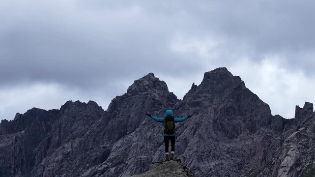 Backpacking woman hiking on flowering grassland mountain top	