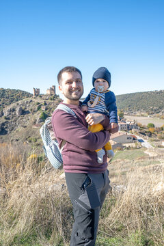 Father holding baby enjoying family travel in Pelegrina, Guadalajara