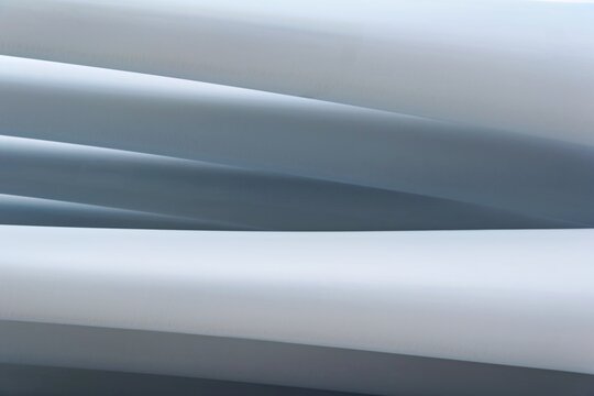 Close-up view of smooth white material flowing in curves, creating an abstract pattern of lines and shapes. This showcases a minimalistic design with soft gradients.