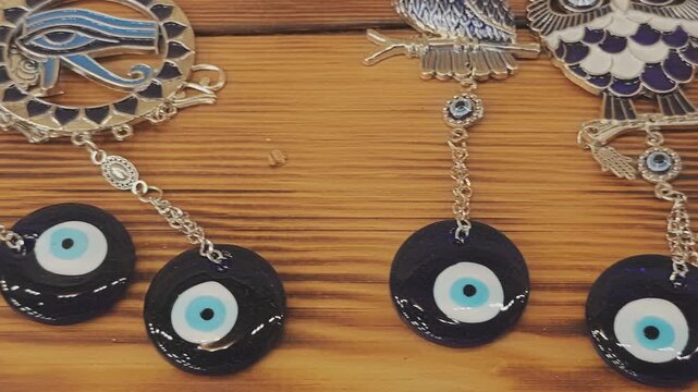 Various traditional lucky charms and amulets, including the Turkish evil eye nazar, Eye of Horus, and hamsa hand, on a wooden table