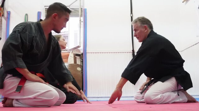 Respectful hapkido students bowing to their sensei master at the beginning of a training session. A traditional martial arts greeting