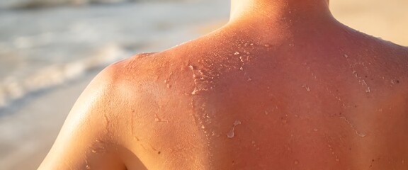 Naklejka premium Sun kissed skin with water droplets on a beach during golden hour
