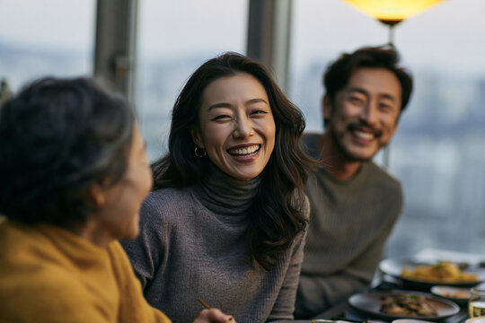 Happy Asian Family Enjoying Dinner Together in Restaurant