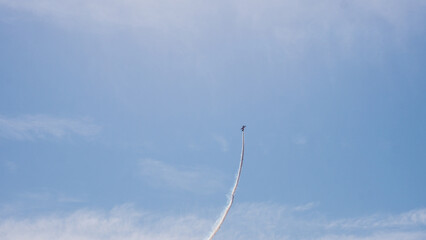 Aerobatic Biplane Trailing a White Smoke Spiral Against a Clear Blue Sky at an Air Show — Precision Flying, Freedom and Adventure Concept © Svetlana