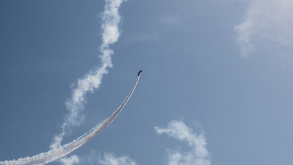 Aerobatic Biplane Trailing a White Smoke Spiral Against a Clear Blue Sky at an Air Show — Precision Flying, Freedom and Adventure Concept © Svetlana