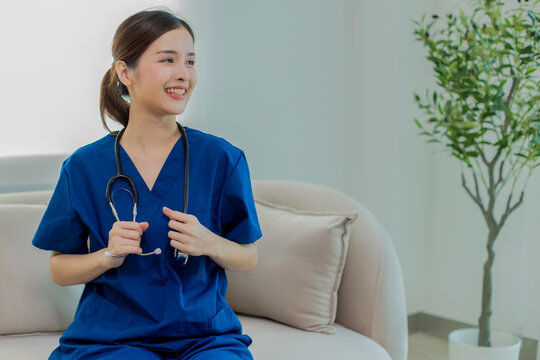 Beautiful Doctor wearing hospital  uniform seat at sofa - Cheerful Asian female  working at the hospital