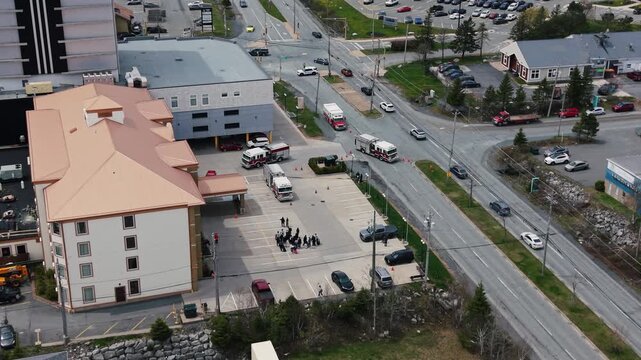 View from above shows fire trucks outside a hotel in Halifax, Nova Scotia. Evacuated guests stand outside, highlighting the urgent response to the situation