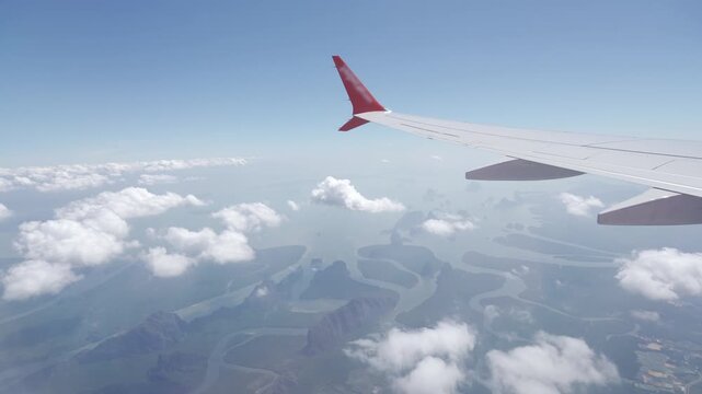 view inside airplane aircraft through window with wing view while flying in sky over puffy cloudy and blue sea ocean in sunny day,Airplane Wings with blue sky travel vacation holiday background