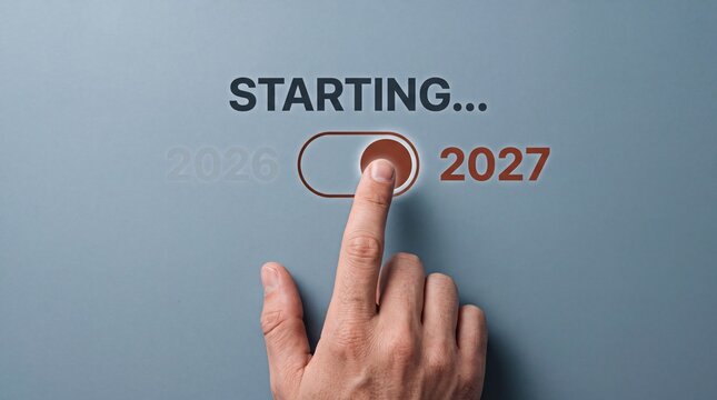 New Year 2027 starting concept. Hand switching toggle button from 2026 to 2027. Minimalist business transition and future planning concept on blue background