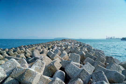 Concrete Breakwater Along Calm Sea Coastline