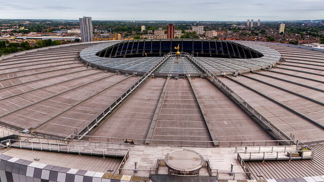 London, England, United Kingdom - 15 August 2026: Aerial view of Tottenham Hotspur Stadium, featuring its unique roof structure and the golden cockerel emblem above the urban landscape.