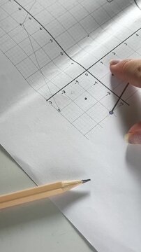 Student marking points on a coordinate graph during a math lesson, coordinate geometry, learning and academic education.