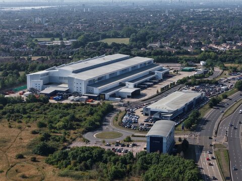 Waltham Cross, United Kingdom - 10 August 2025: Aerial view of the Newsprinters Holdings Limited print works facility, featuring large industrial buildings, parking lots, and surrounding greenery.