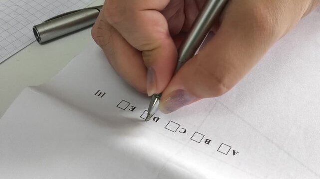 Student checking an answer on an exam paper, academic testing, education, college admission and university application concept.