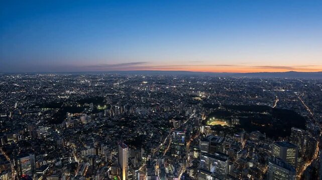 Aerial cityscape transitioning from night to sunrise

