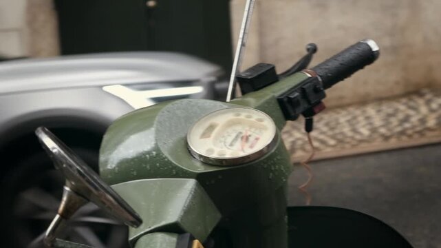 Close-up view of a vintage scooter handlebar and speedometer parked on a historic Lisbon street, capturing urban travel atmosphere, classic transportation details and the character of Portugal's capit